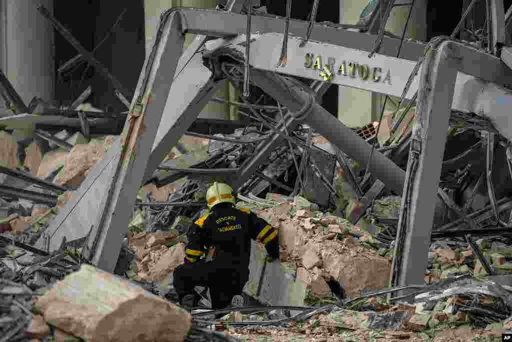 Un rescatista busca sobrevivientes en el lugar de una explosión mortal que dañó el hotel Saratoga, en La Habana, el viernes 6 de mayo de 2022. (AP Foto/Ramón Espinosa)