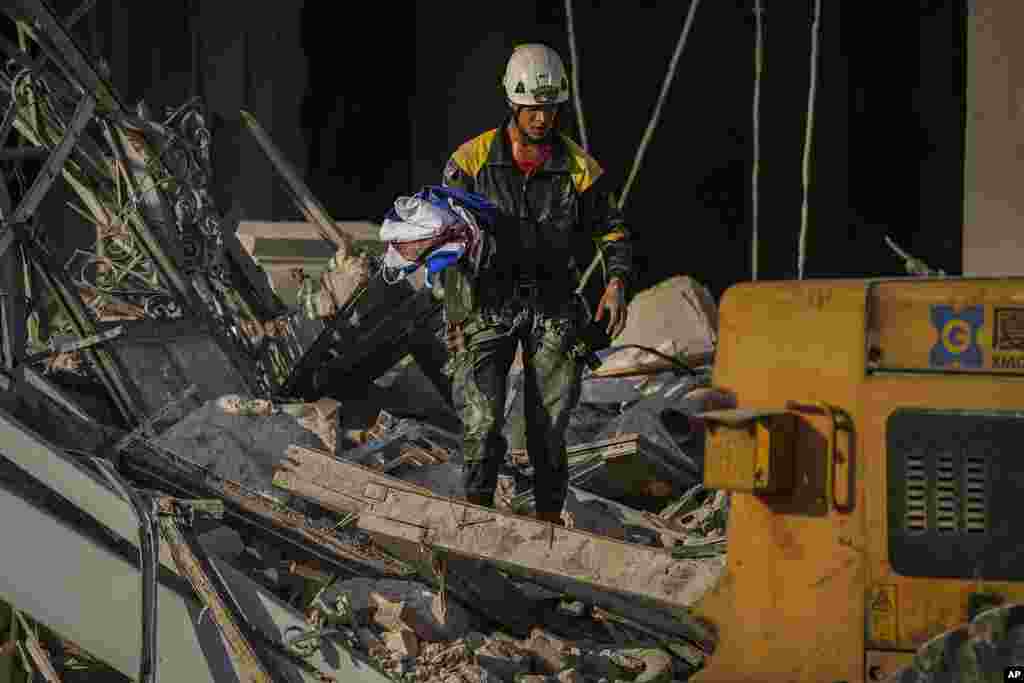 Un rescatista carga una bandera cubana recuperada en el lugar de una explosión mortal que dañó el hotel Saratoga, en La Habana, el viernes 6 de mayo de 2022. (AP Foto/Ramón Espinosa)