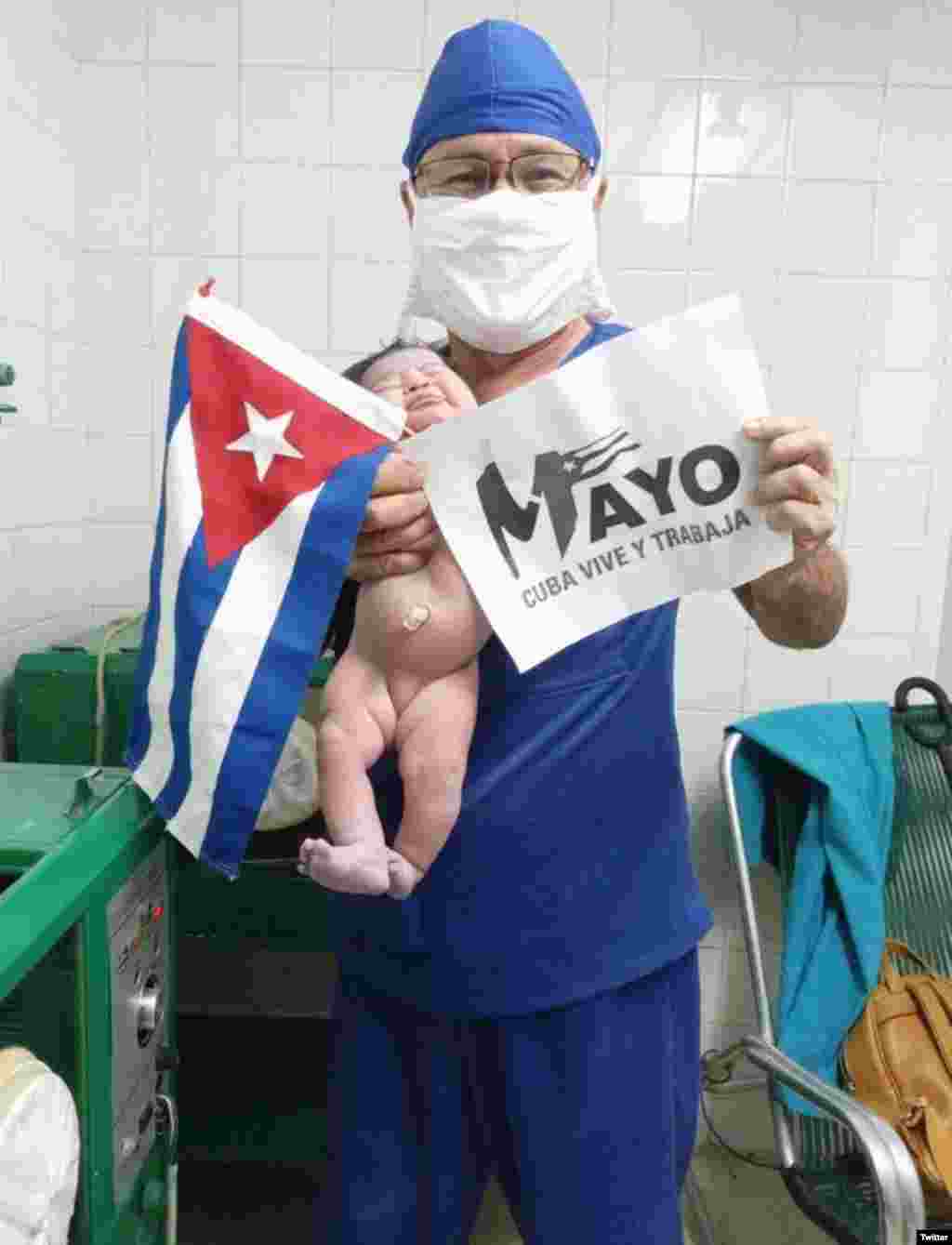 "Este médico holguinero inició la celebración del #1Mayo acompañado de una recién nacida a la que ayudó a venir a este mundo. De ahí dice que fue para la Plaza", tuiteó el PCC. (Foto: Twitter/@PartidoPCC)
