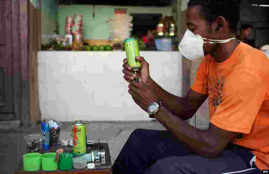Archivo 2014.- Un trabajador por cuenta propia rellena fosforeras por una calle de La Habana (Cuba).