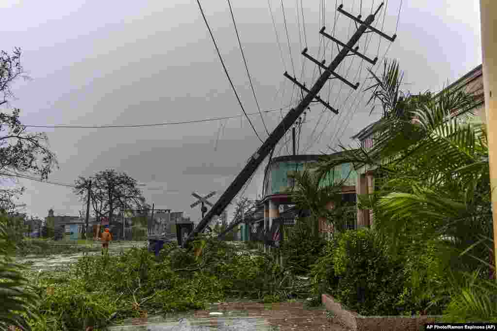 Postes de luz caídos bordean una calle después de que el huracán Ian azotara Pinar del Río, Cuba, el martes 27 de septiembre de 2022.Daños causados por el huracán Ian en Pinar del Río, Cuba.
