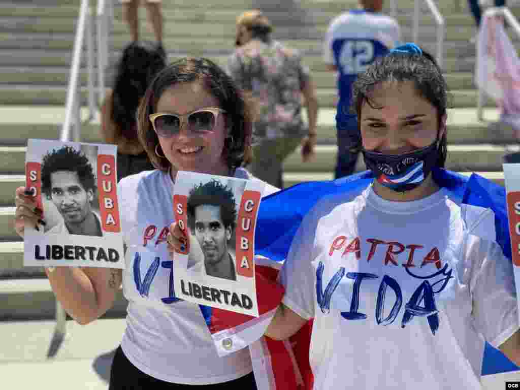 Dos jóvenes con la consigna de Patria y Vida