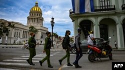 Oficiales de policía caminan cerca del Capitolio, sede de la Asamblea Nacional, en La Habana. (YAMIL LAGE / AFP)