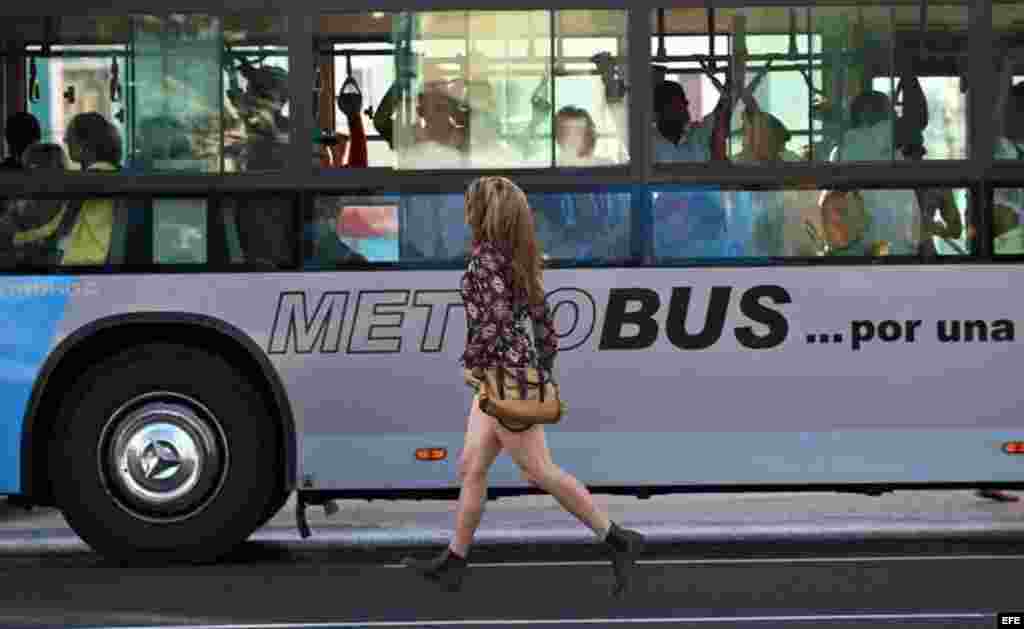 Una joven corre para alcanzar un autobús en La Habana (Cuba), este viernes, 20 de enero de 2017, día en que el magnate estadounidense Donald Trump asume la presidencia de EEUU. 