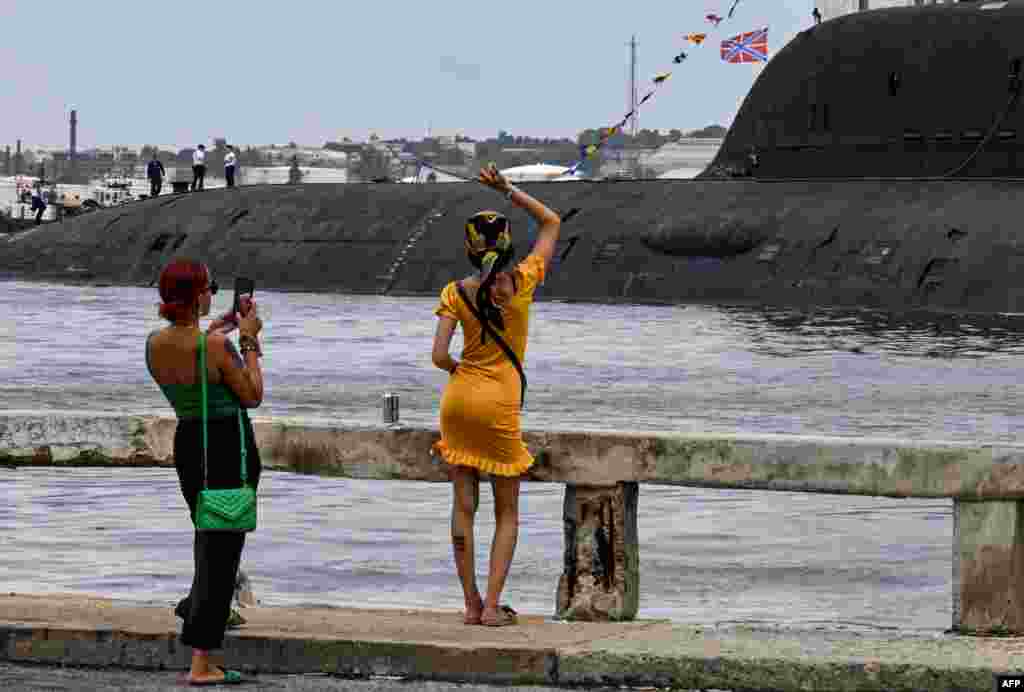 Una mujer saluda a los miembros de la tripulación del submarino de propulsión nuclear Kazán, parte del destacamento naval ruso que visita Cuba, después de su llegada al puerto de La Habana el 12 de junio de 2024. YAMIL LAGE / AFP