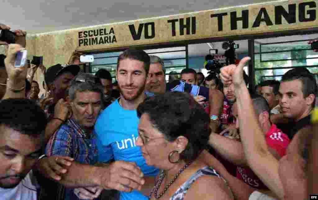 Aficionados al fútbol persiguieron al defensa madridista Sergio Ramos y lo recibieron con aplausos y gritos en la visita que cursó a una escuela habanera. 