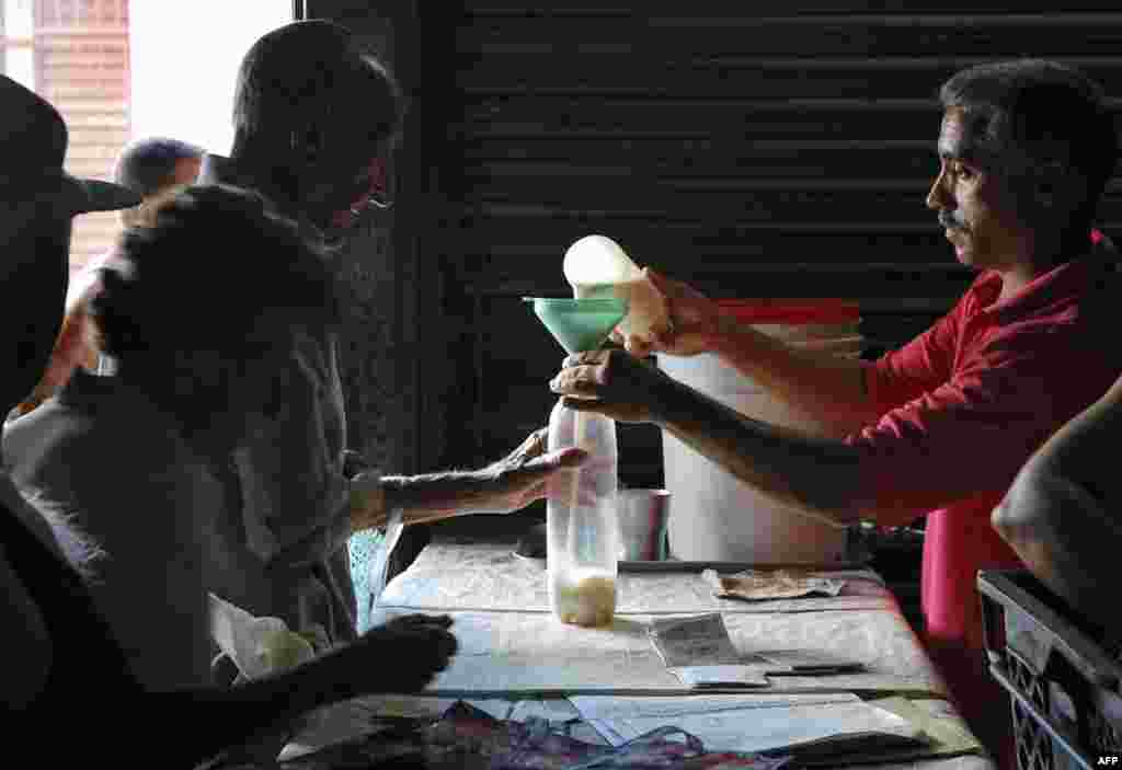 Un hombre compra leche en una bodega de Cuba. Un tercio de la población come dos o menos veces por día. AFP PHOTO / STR