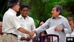 El jefe negociador del gobierno colombiano, Gustavo Bell (i), estrecha la mano del comandante del ELN Israel Ramírez Pineda (d), alias Pablo Beltrán, en La Habana.