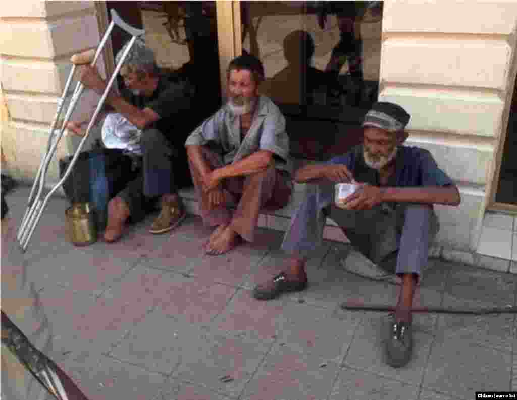 tres indigentes alimentándose en el céntrico boulevard, ubicado en la calle Crombet entre Calixto García y Los Maceos, el que tiene las muletas es un ex combatiente de la guerra de Angola. 
