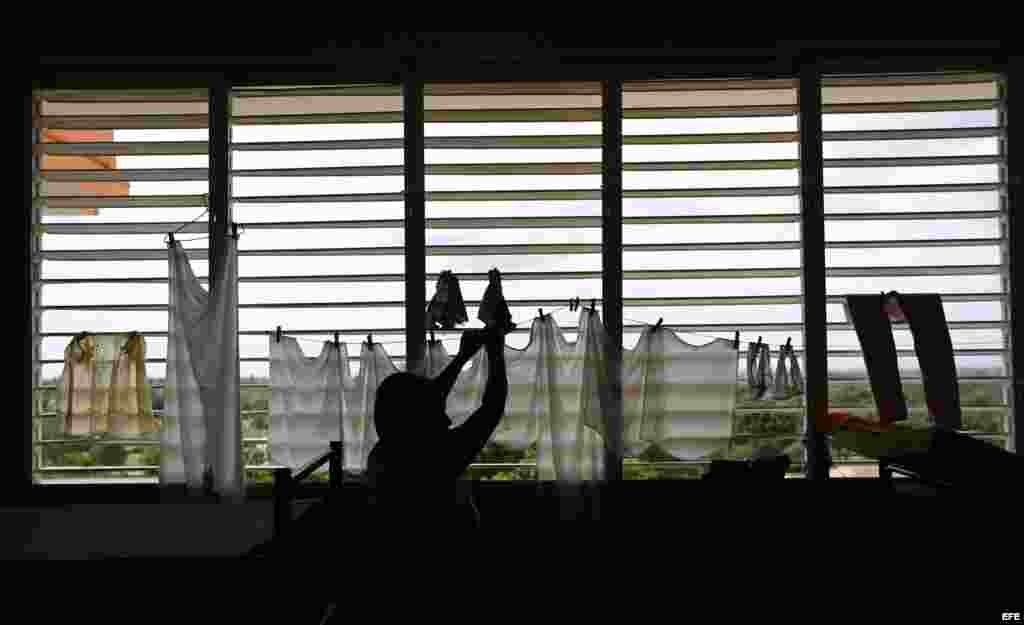 Una mujer cuelga ropa en un albergue hoy, lunes 03 de octubre de 2016, en la ciudad de Guantánamo (Cuba), ante la proximidad del huracán Matthew. Seis provincias de Cuba se encuentran bajo "alarma ciclónica" a la espera del potencial impacto del huracán