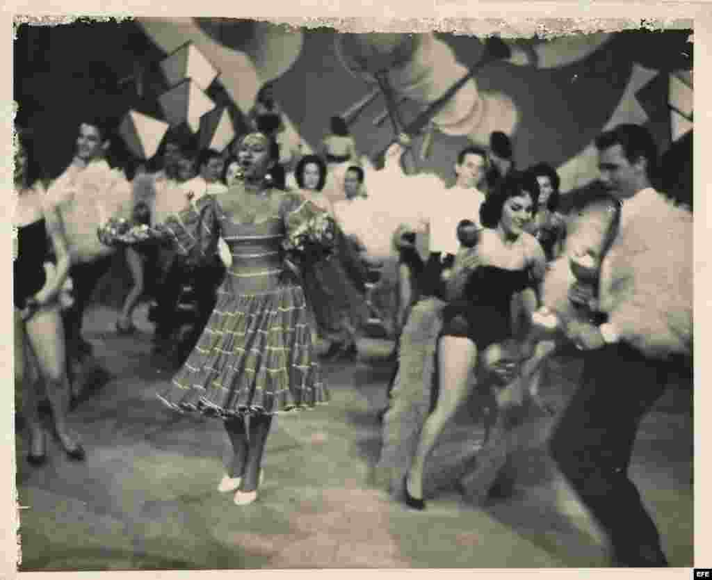 Celia Cruz durante la década de los años 50, con un traje azul de algodón en la presentación de una revista musical.