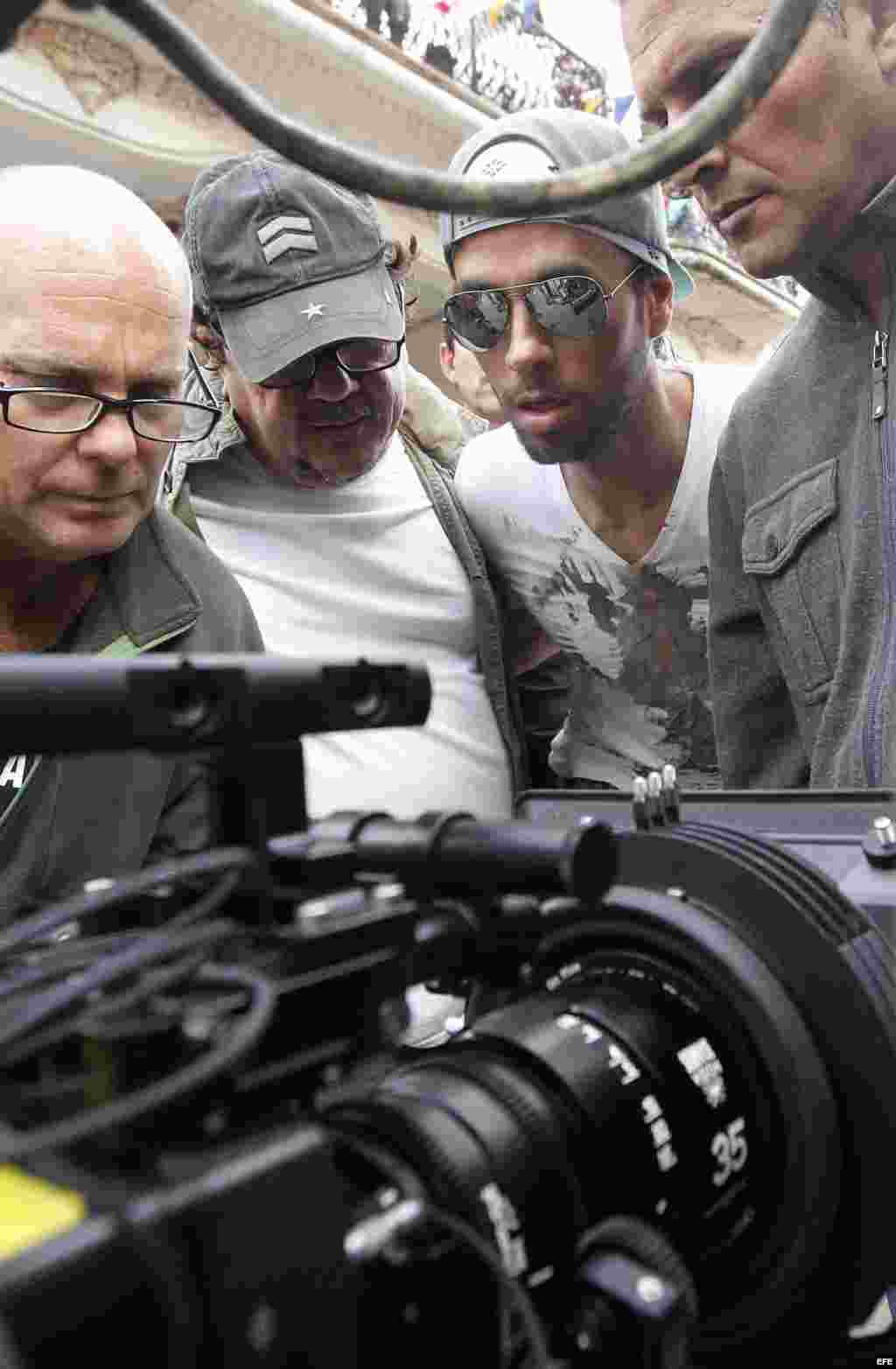 El cantante español Enrique Iglesias (2-d), observa una de las escenas filmadas, junto al director Alejandro Pérez(2-i) el 10 de enero de 2017, en la filmación del videoclip de su sencillo "Súbeme la radio", en La Habana (Cuba). Iglesias filma en Cuba el