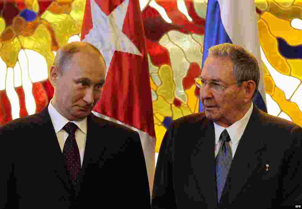 Raúl Castro (d) y su homólogo de Rusia Vladimir Putin (i) hablan antes de hacer declaraciones a la prensa.
