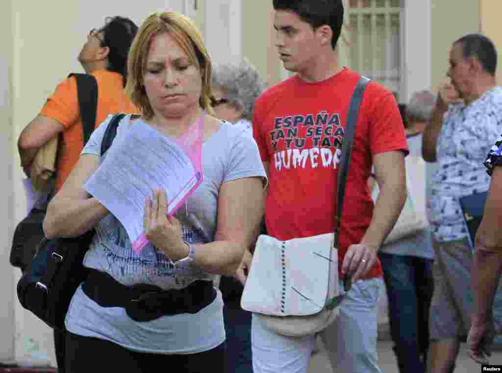 Una cubana revisa sus papeles tras visitar una oficina de inmigración en La Habana, Cuba.