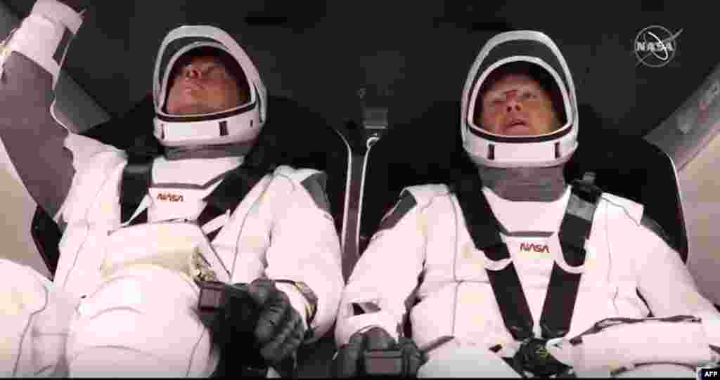 Foto del interior de la cápsula SpaceX Crew Dragon con los astronautas Bob Behnken (izquierda) y Doug Hurley. (Foto AFP tomada de NASA TV)