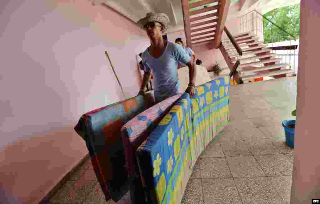 Un hombre carga colchones para las personas albergadas en una escuela hoy, lunes 03 de octubre de 2016, en la ciudad de Guantánamo (Cuba), ante la proximidad del huracán Matthew. Seis provincias de Cuba se encuentran bajo "alarma ciclónica" a la espera d