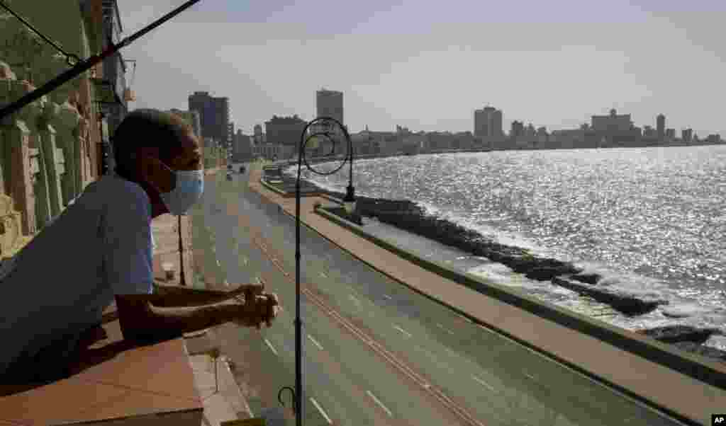 El trabajador Julio Diago mira la carretera vacía a lo largo del malecón desde el restaurante Nazdarovie, que está cerrado por la cuarentena. (AP/Ismael Francisco)