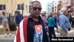 Daniel Llorente se manifiesta envuelto en una bandera estadounidense a la llegada del crucero Adonia a La Habana, en mayo de 2016.