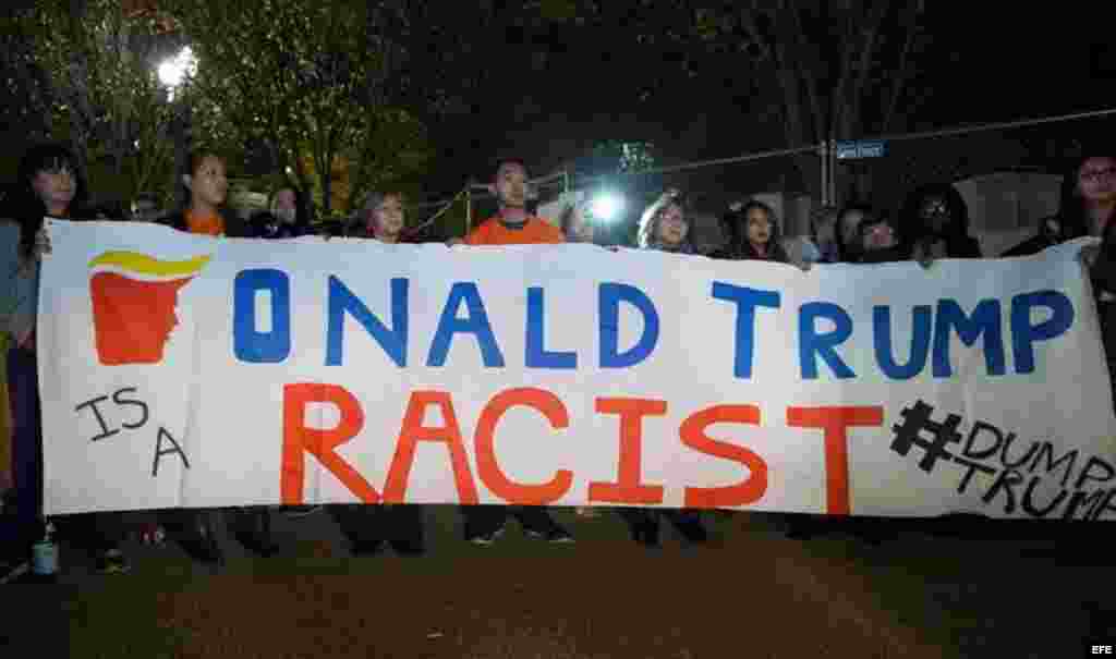 Unos inmigrantes en Washington sostienen una pancarta en la que se lee "Donald Trump es un racista". 