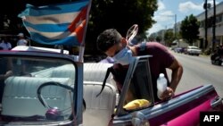 Un cuentapropista desinfecta su auto en La Habana para evitar la transmisión del coronavirus. (YAMIL LAGE / AFP)