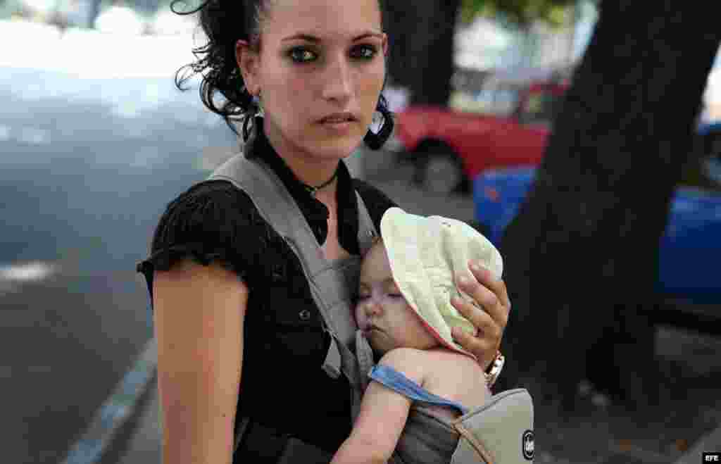 Una mujer carga a su pequeño hijo en La Habana (Cuba)agosto de 2014. Para el año 2030 o quizás antes la población de Cuba baje de 11 millones de habitantes, de un aproximado actual de 11 millones 167 mil.