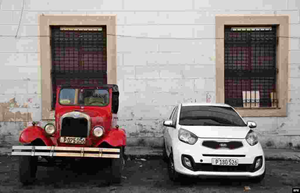 Dos vehículos uno antiguo y uno moderno permanecen estacionados en una calle de La Habana (Cuba), este viernes, 20 de enero de 2017, día en que Donald Trump asume la presidencia de EEUU. 