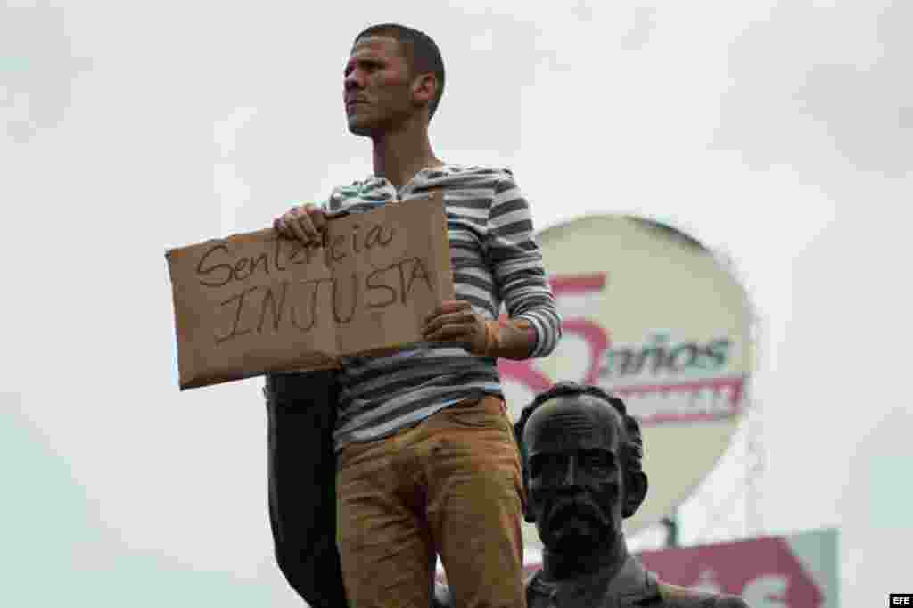 Un hombre sostiene un cartel con el mensaje "sentencia injusta" en referencia a la condena de 13 años y nueve meses de prisión, dictada contra el dirigente opositor.