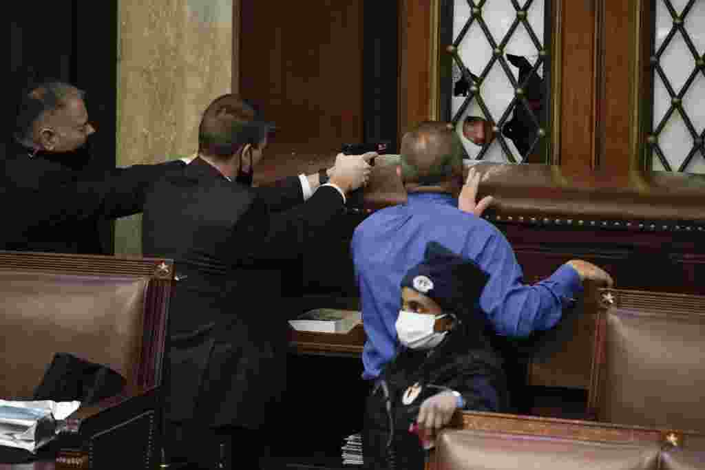 La policía con armas en la mano observa cómo los manifestantes intentan irrumpir en la Cámara de la Cámara en el Capitolio de los Estados Unidos, en Washington. (AP / J. Scott Applewhite)
