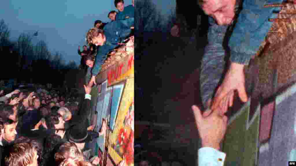 El canciller alemán, Helmut Kohl (c), estrecha la mano a un ciudadano berlinés que se encuentra encaramado en lo alto del Muro de Berlín cerca de la Puerta de Brandemburgo, en Berlín (Alemania).