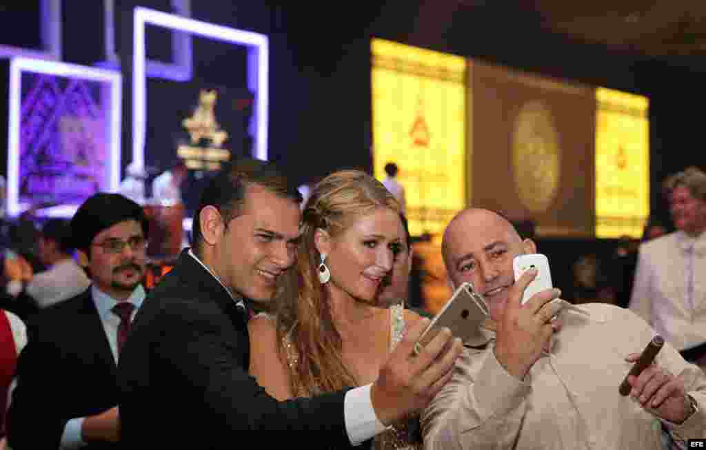 La celebridad estadounidense Paris Hilton (c), heredera del imperio hotelero de su apellido, posa con dos asistentes a su llegada a la cena de gala que cerró el XVII Festival Internacional del Habano. 
